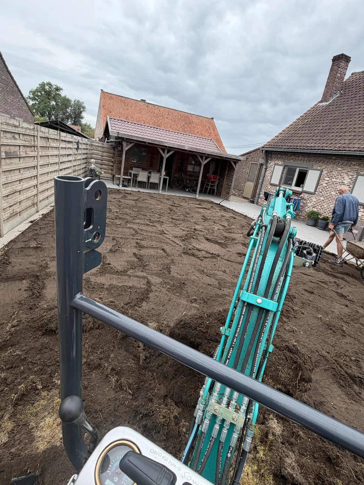 Graafmachine aan het werk tijdens de grondwerken in een tuin