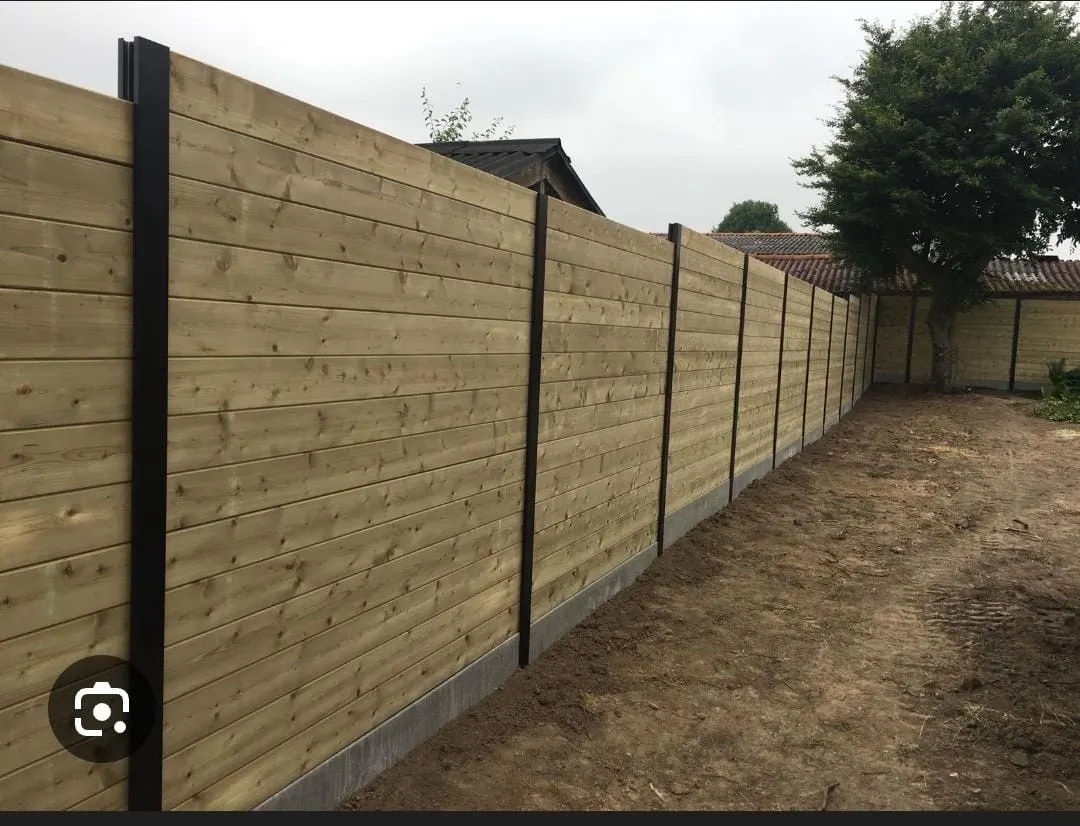 Nieuwe houten omheining met betonpalen in een tuin te Jabbeke