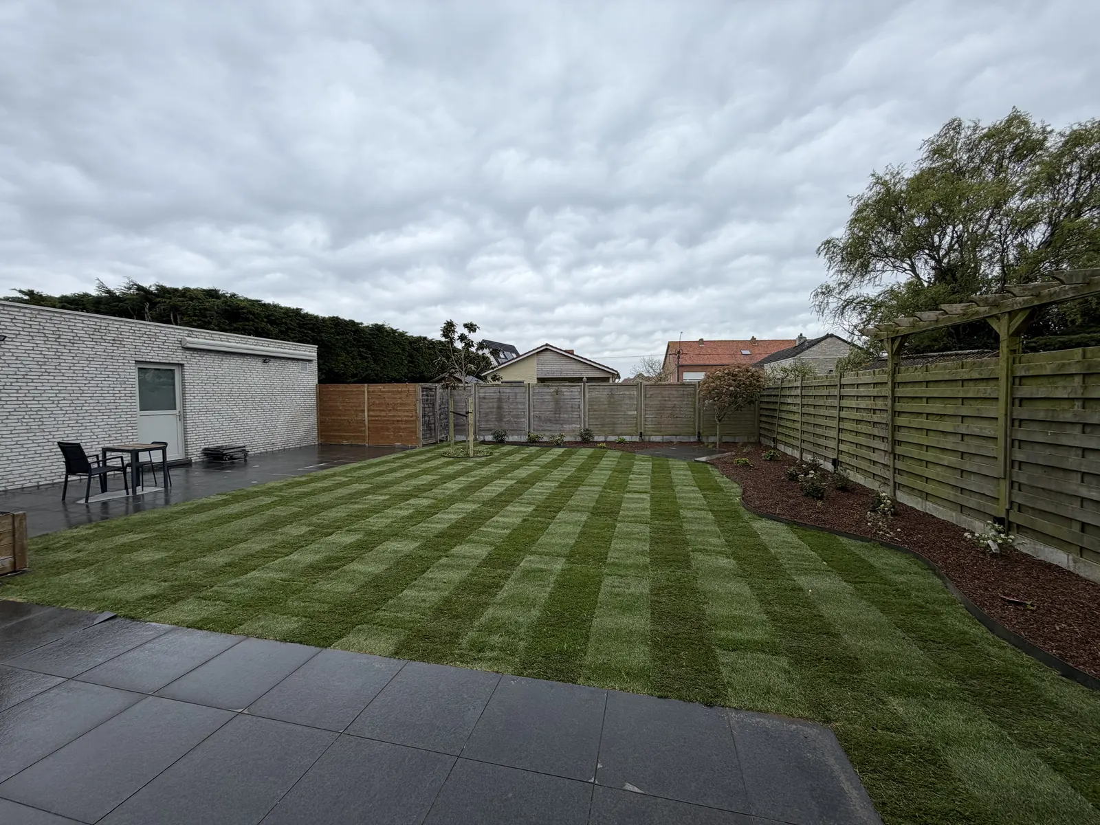 Volledig heraangelegde tuin met nieuw gazon, terras en omheining